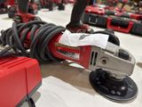 a corded sander on a table with other tools in the background