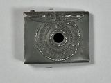 a silver lighter that has a black hole in it