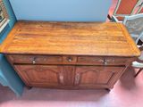 a wooden cabinet with two drawers and a mirror on the wall