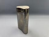 a close up of a silver lighter on a white surface