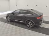 the rear end of a black car in a clean garage