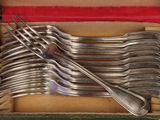a lot of forks and spoons in a box