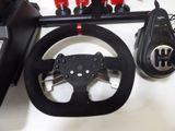 a steering wheel and some remote controls on a table
