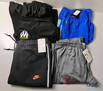 trois paires de pantalons et une veste posés sur une table
