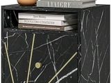 une commode en marbre noir sur laquelle sont posés des livres et un vase
