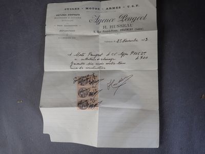un vieux document sur lequel repose un bout de papier, posé sur une table