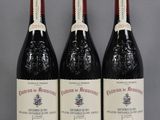 three bottles of red wine sitting on top of a table