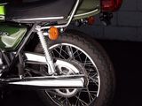 a green motorcycle that is parked in a garage