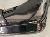 a close up of a shiny black shoe with a gold buckle