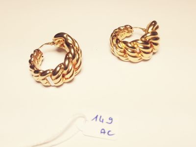 two pairs of gold hoop earrings on a white surface