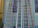 many ladders leaning up against the side of a building
