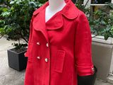 a red coat on a mannequin stand outside