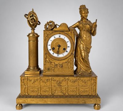 une horloge en or surmontée d'une statue