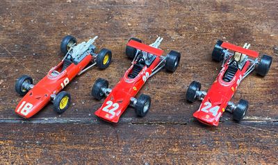 quatre petites voitures de course alignées sur une table en bois