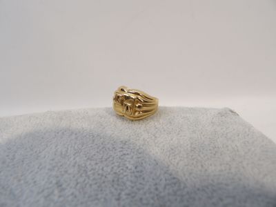 gros plan d'une bague en or sur une surface blanche