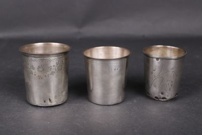 trois coupes en argent ornées de motifs, posées sur une surface noire