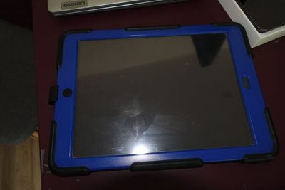 une tablette bleue posée sur une table à côté d'un ordinateur portable
