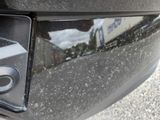 a close up of a car door handle with a reflection of a building in the background