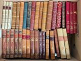 a box full of old books sitting on top of each other