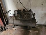 a small air compressor sitting in a room next to a wall