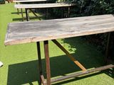 two wooden tables sitting on the grass in the yard