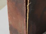 an old brown leather suitcase sitting on top of a white table