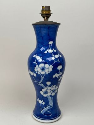 a blue vase with white flowers on it sitting on a table