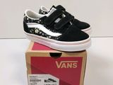Des baskets Vans Old Skool dans une boîte posée sur une surface blanche