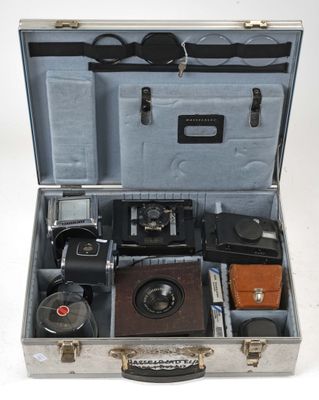 an open suitcase with a camera and other items in it