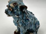 blue dog figurine sitting on a white surface with a white background