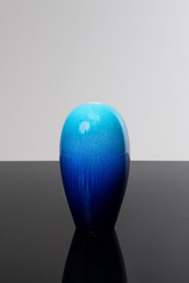 une pomme bleue posée sur une table noire