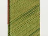 un livre à la couverture verte posé sur une table blanche