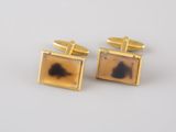 a pair of gold cufflinks with a ace in the middle