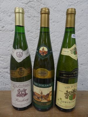 trois bouteilles de vin posées sur une table, l'une à côté de l'autre