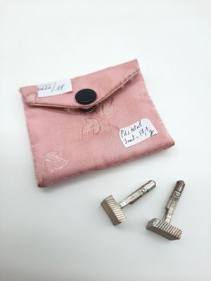 une petite pochette rose avec une paire de ciseaux à côté
