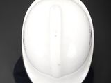 a white hard hat sitting on top of a black surface