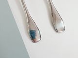 two spoons and a fork sitting on a table