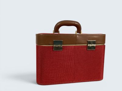the red and brown briefcase is sitting on a white surface