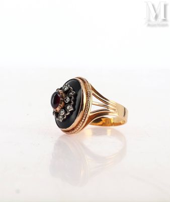 an image of a gold ring with a black stone surrounded by diamonds