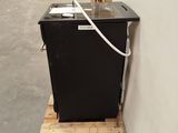 a black dishwasher sitting on a pallet in a warehouse