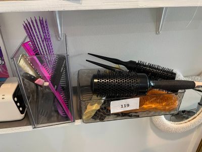 un sèche-cheveux, des peignes et d'autres produits capillaires posés sur une étagère