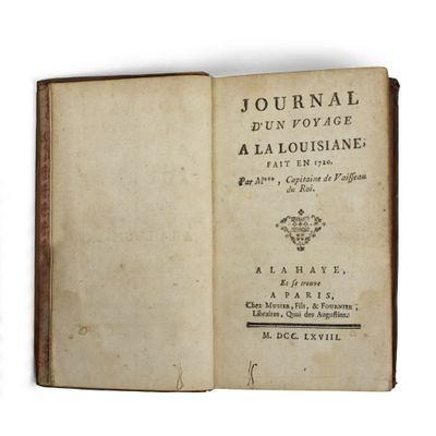 un livre ouvert posé sur une surface blanche, avec l'image d'une couronne