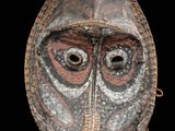 gros plan d'un masque en bois sur fond noir
