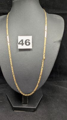 un gros plan d'un collier porté par un mannequin, sur lequel figure le chiffre 46