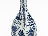 a blue and white vase sitting on a white surface