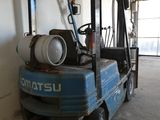 un petit camion bleu avec un bidon d'essence à l'arrière
