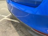 a close up of a blue car parked in a parking lot