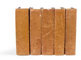 plusieurs livres marron empilés les uns sur les autres sur une surface blanche