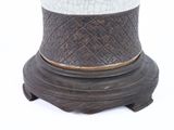 a white and black vase sitting on a stand