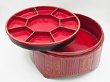a red box with a lid that has a design on it
